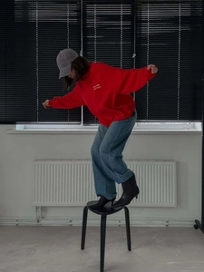 Red letter embroidery crewneck sweatshirt paired with loose jeans and boots