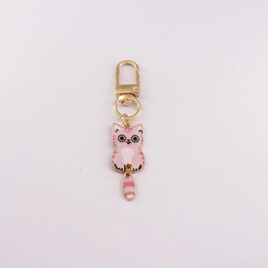 Detailed close-up of a pink cartoon cat keychain with golden metal clasp on white background