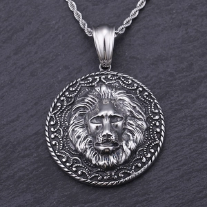 Detail of vintage lion head pendant with textured rope border and twisted chain