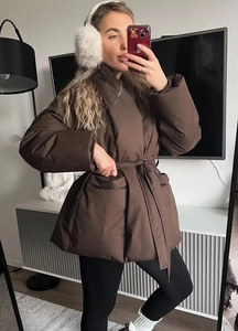 Close-up of brown padded winter coat featuring a large lapel and waist tie detail