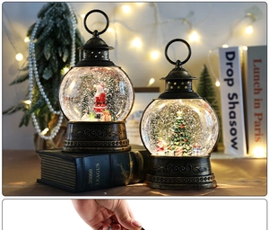 Close-up of Santa and Christmas tree snow globes with warm festive lighting and details