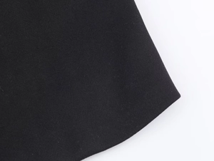 Macro shot of black wool fabric texture and curved hem detail of the casual coat