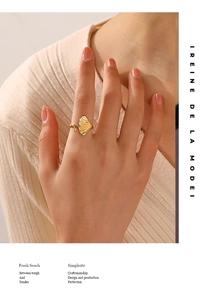Golden ginkgo leaf open ring on model finger featuring high-polish stainless steel