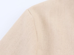 Detailed macro view of beige lace stitching and soft knit fabric texture on women's blouse