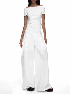 Détail d'un haut à épaules dénudées et d'un pantalon large en blanc minimaliste