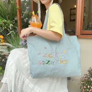 Détail du sac cabas en toile bleu clair avec broderie Lucky Suzakka pour l'usage quotidien