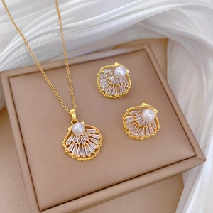Elegant gold shell jewelry set with zircon crystals and pearls on silk fabric