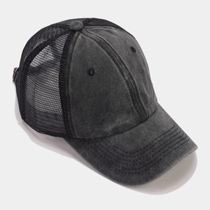 Detail view of washed vintage trucker hat showing breathable black mesh and durable stitching