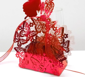 Detail of red laser-cut butterfly candy box with pearlescent paper and matching silk ribbon