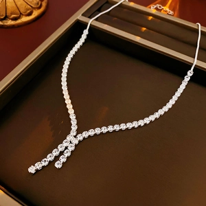 Macro shot of silver V-shaped necklace with zircon fringe on a jewelry display tray
