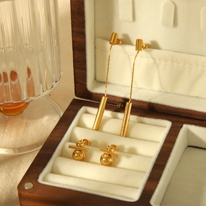 Vintage gold tassel titanium steel earrings displayed in a luxury jewelry box