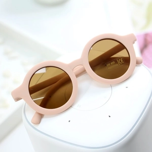 Close-up of pink round matte kids sunglasses on stand with UV400 and CE certification