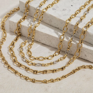 Gros plan de colliers à chaînes superposées en acier inoxydable plaqué or 18 carats