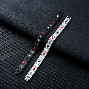Detailed macro view of black and silver magnetic therapy bracelets on leather surface