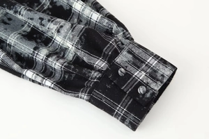 Détail du poignet d'une chemise à carreaux avec double bouton et couture de précision