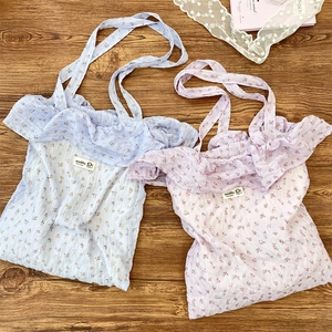 Detailed close-up of floral chiffon tote bags with ruffle edges in blue and pink