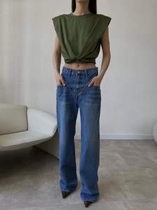 Detail of high-waist straight-leg blue denim jeans paired with a green crop top