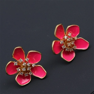 Detailed close-up of pink enamel flower earrings with gold plating and cubic zirconia