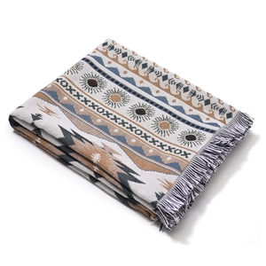 Détail d'une couverture tissée bohème avec motifs géométriques et franges douces sur le bord