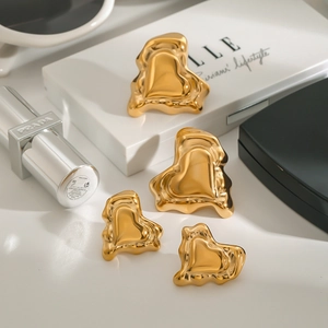 Détail macro des boucles d'oreilles cœur fondu doré avec finition miroir polie