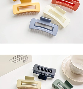 Detailed view of matte rectangular hollow hair claws in various pastel colors on a white base