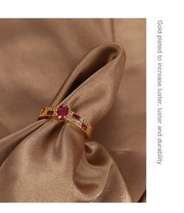 Macro shot of 18K gold plated ring featuring oval red zircon and rectangle side stones
