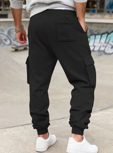 Rear view of black cargo joggers featuring tactical side pockets and elastic ankle cuffs