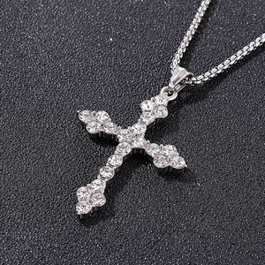 Vue macro d'un pendentif croix hip-hop avec strass brillants sur cuir noir