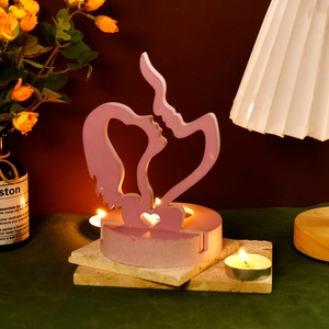Close-up of pink kissing couple candle holder with heart cutout and matte finish