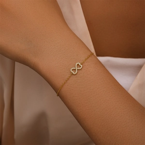 Macro shot of s925 silver gold bracelet featuring infinity heart and sparkling zircons