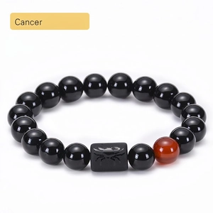 Detail of Cancer zodiac bracelet with black onyx beads and engraved crab symbol stone