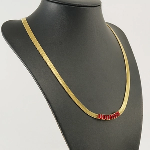 Detailed shot of 18K gold plated snake chain with rectangular red zircon stones