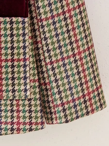 Detail of colorful houndstooth fabric with deep red velvet patch and side pocket