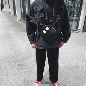 Detail of crossbody bag with ghost eye design worn with casual denim jacket and red shoes