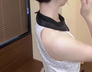 Detail of white sleeveless top with black polka dots and semi-transparent black scarf