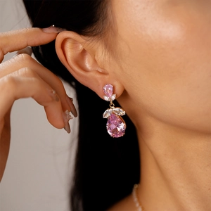 Gros plan de boucles d'oreilles en zircon rose en forme de goutte avec détails en métal doré