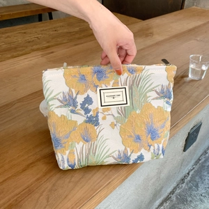 Detail of floral brocade makeup bag with metal zipper and Pleasant Time label