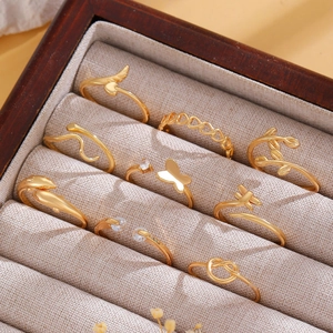 Close-up of 10-piece gold ring set with heart and butterfly charms in a jewelry box