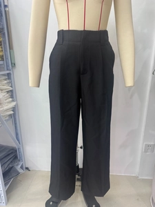 Close-up of black high-waisted wide-leg trousers showing smooth draped fabric texture