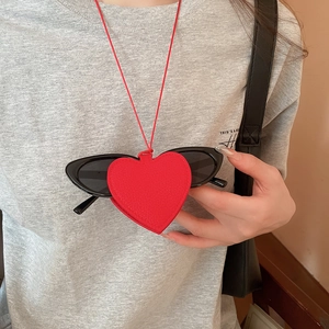 Close-up of red heart leather sunglass holder pendant worn as a stylish neck accessory