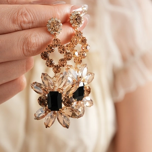 Gros plan de boucles d'oreilles vintage avec cristaux ambre et pierre noire centrale