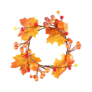 Fall candle ring with maple leaves, orange pumpkins and red berries for festive decor