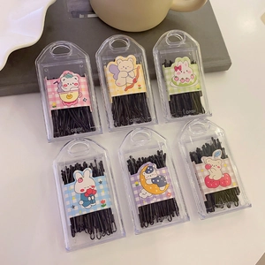 Black bobby pin set in cute cartoon storage boxes arranged neatly on a desk