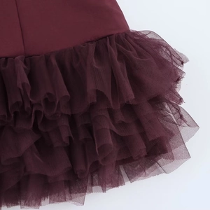 Detailed close-up of layered tulle fabric and pleated texture on a wine red dress