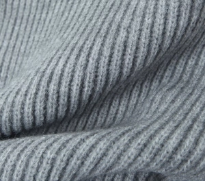 Detailed macro view of soft grey knit fabric showing texture and ribbed stitch patterns
