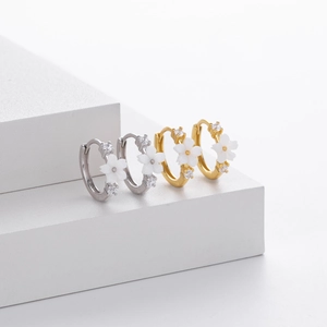 Detail view of gold and silver S925 flower hoop earrings with zircon on display stands