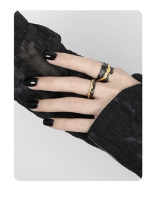 Macro shot of black and gold two-tone rings featuring irregular lava texture design
