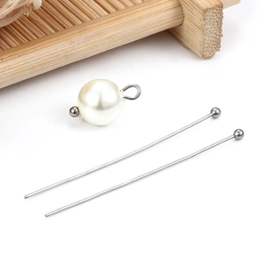 Dettaglio di spilli a sfera in acciaio argento e perla bianca per creazione gioielli