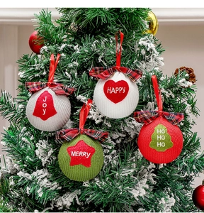 Detailed view of knitted Christmas ball ornaments with holiday motifs on a festive tree
