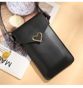 Detail of crossbody phone bag with gold heart buckle on black premium faux leather
